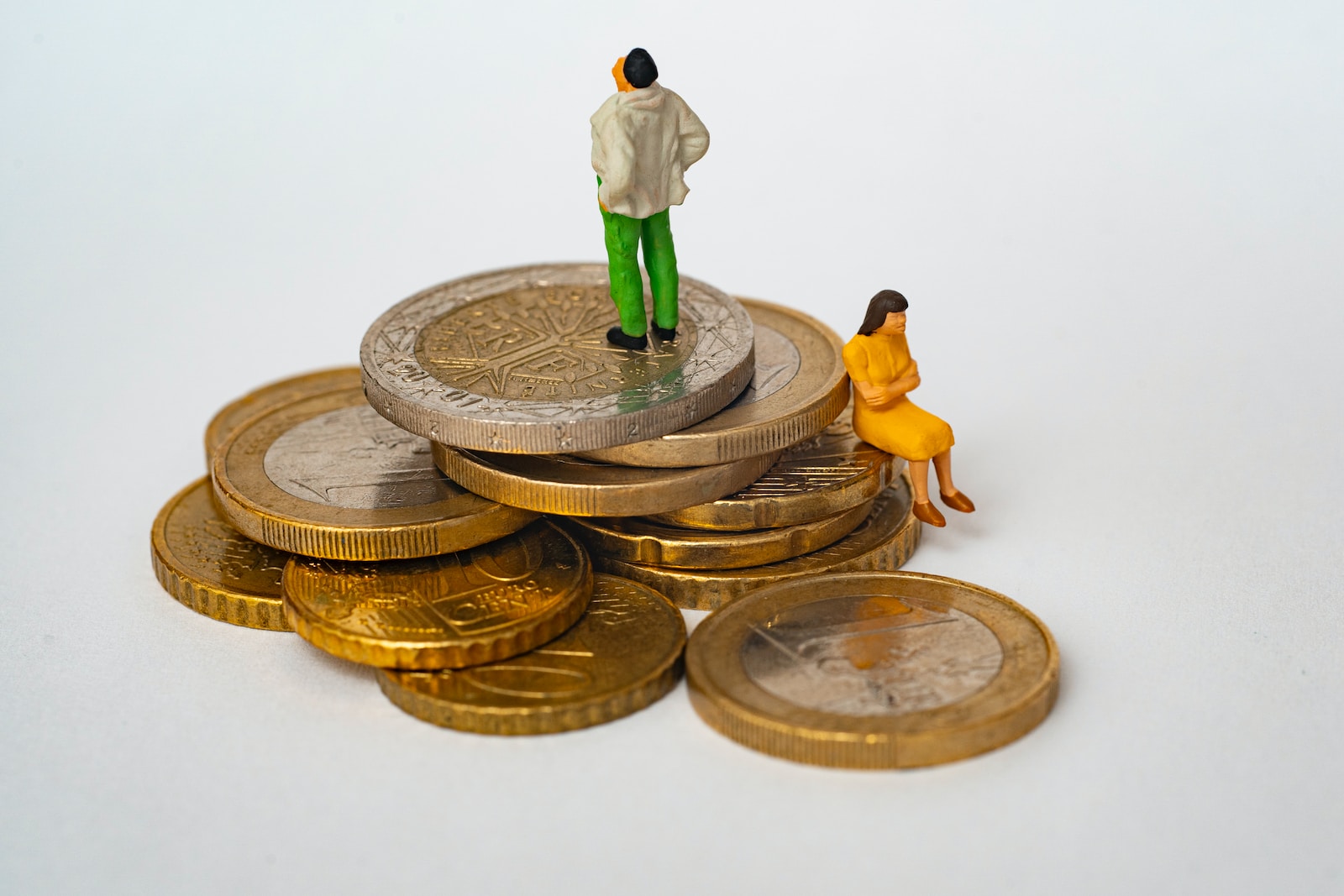 Un homme et une femme debout au sommet d’une pile de pièces de monnaie.