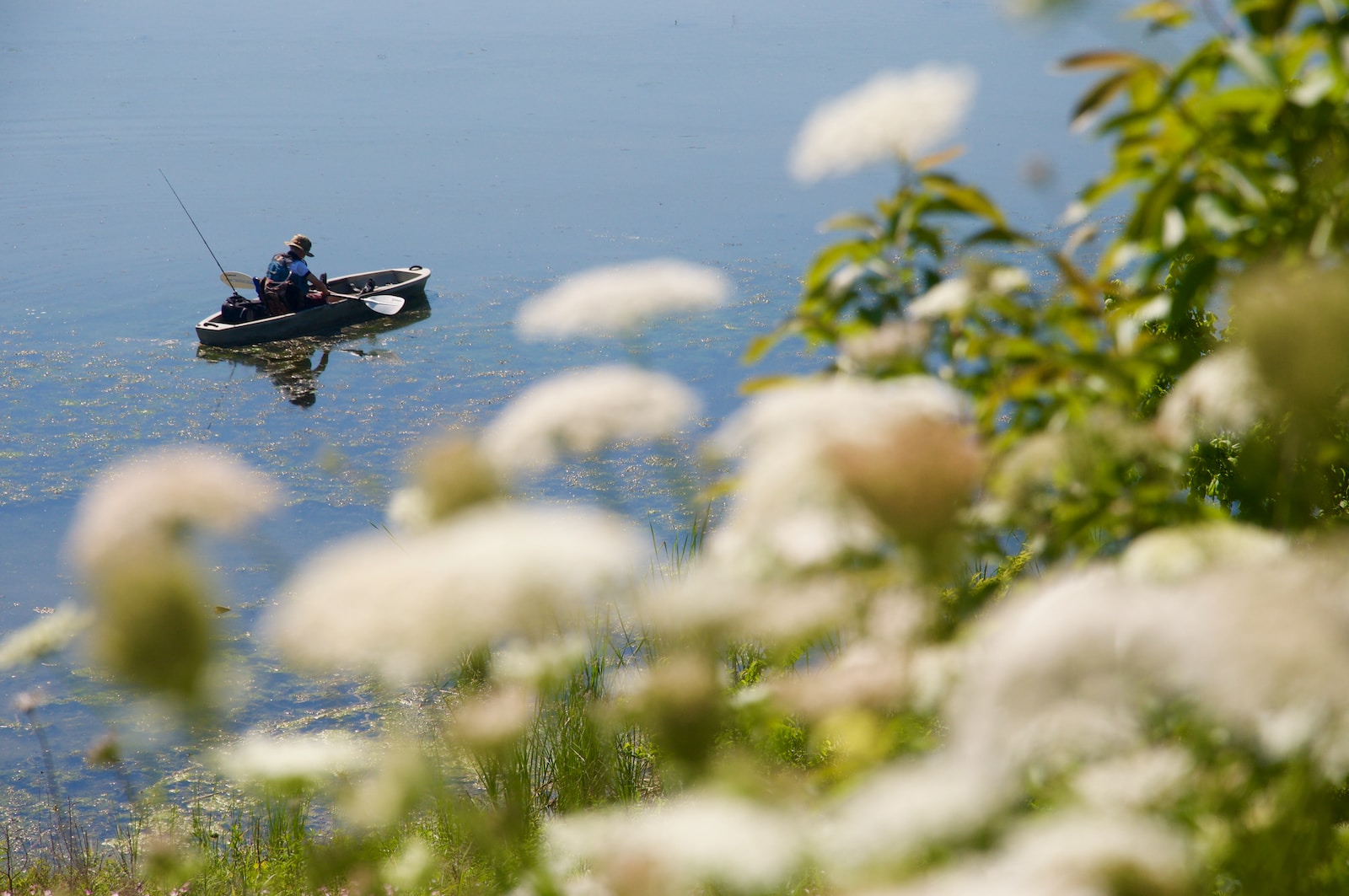 Un homme pêche dans un bateau sur un lac.