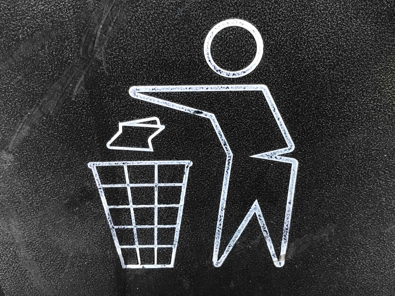 Un homme jetant un papier dans une poubelle.