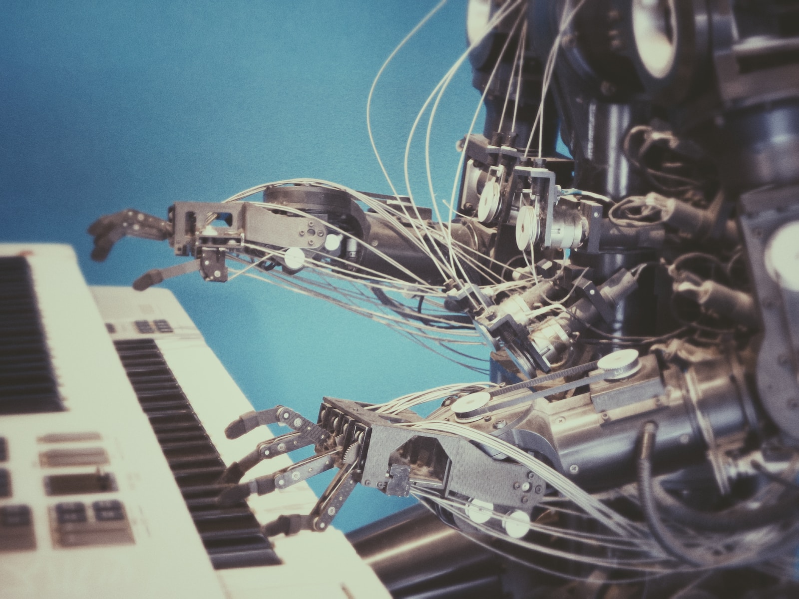 Un robot joue au clavier sur fond bleu.