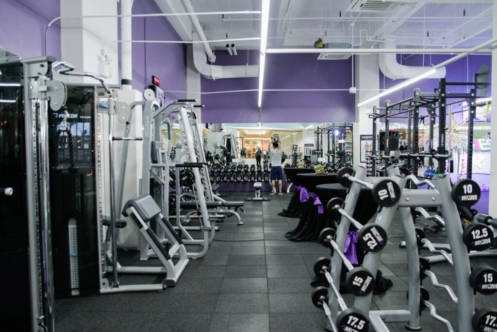 Une salle de sport avec des murs et des équipements violets.