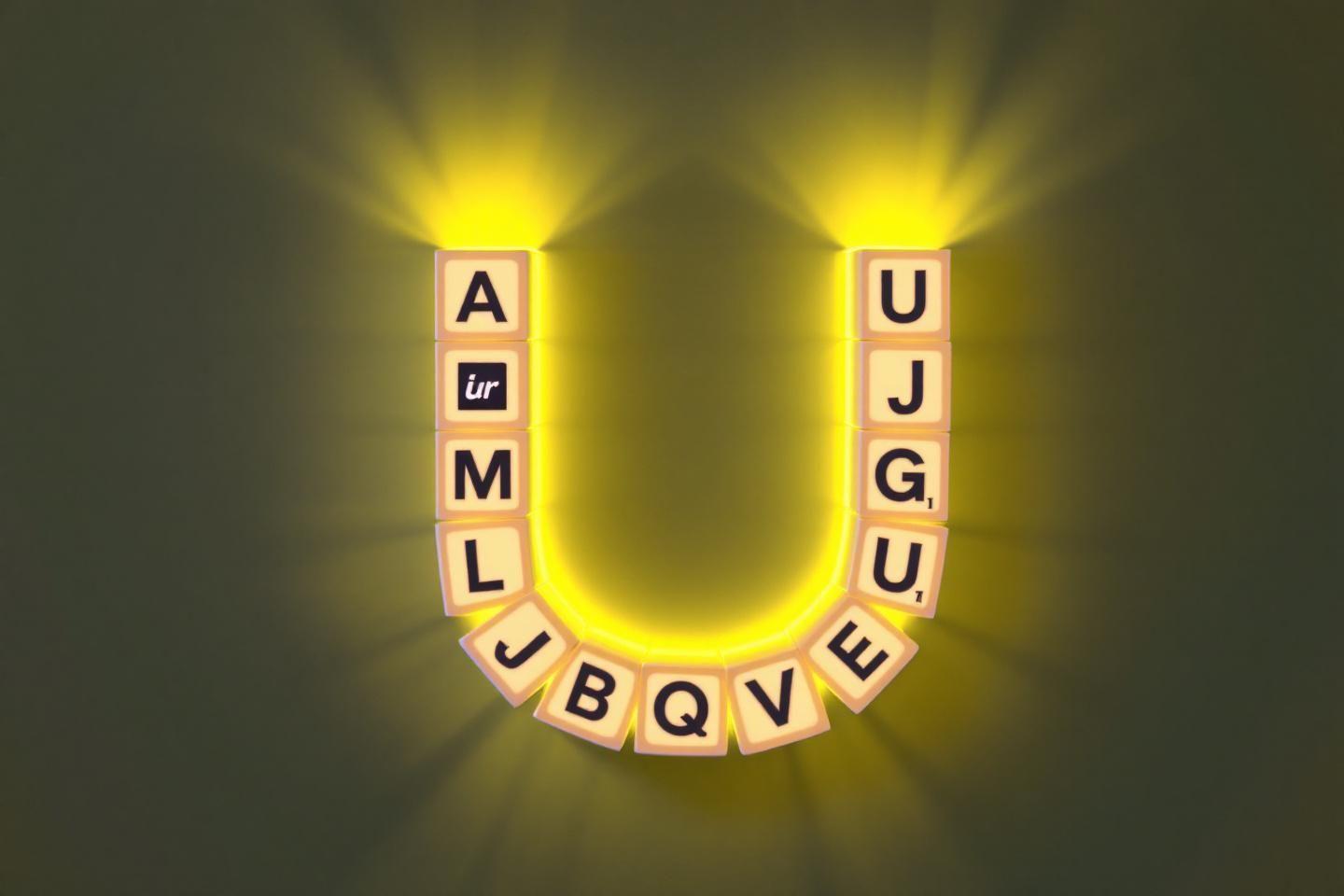 Lettres scrabble disposées en U avec lumière jaune