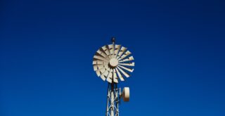 Un moulin à vent contre un ciel bleu.