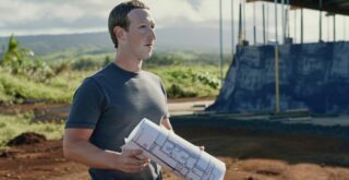 Le fondateur de Facebook, Mark Zuckerberg, tient des plans devant un chantier de construction.